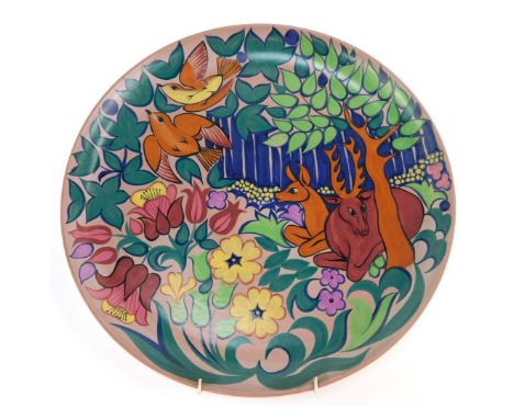A Poole pottery charger, decorated with stag and deer among trees and foliage with two birds, impressed marks, 32cm diameter.