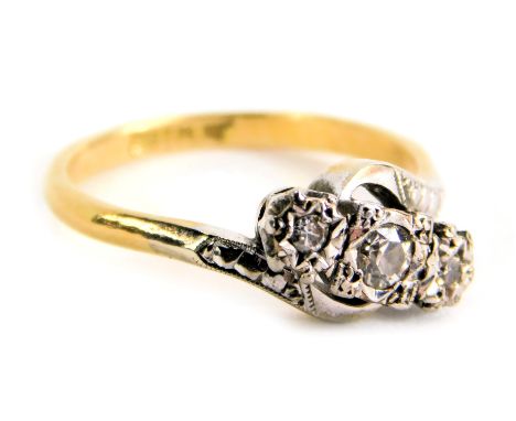 A three stone dress ring, with design of three illusion set tiny diamonds, set in platinum, on twist shoulders, on a yellow m