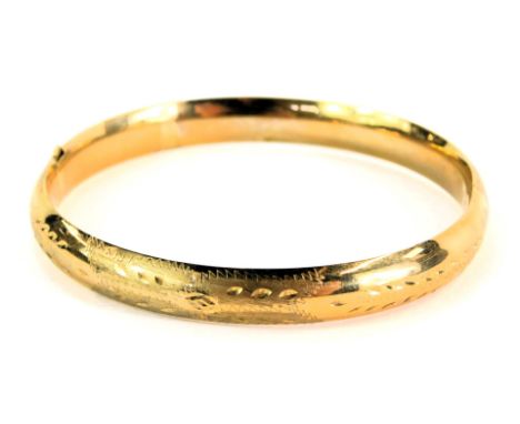 A 9ct gold hollow hinged bangle, with petallated and hammered decoration, 6cm diameter, 8.8g, boxed. 