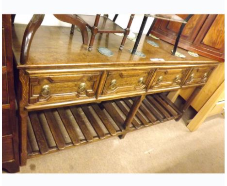 An Oak Dresser Base fitted with four geometric moulded frieze drawers over a slatted shelf, on plain stile feet, 68  wide  