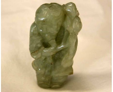 A Chinese Celadon Jade carving of an Old Man clutching a sprig of foliage, (cracks throughout), 3 high