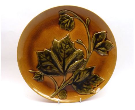 A large Linthorpe Pottery Plate by Florence Mintoe, decorated with stylised grapevine detail in greens and oranges, 11 =  dia