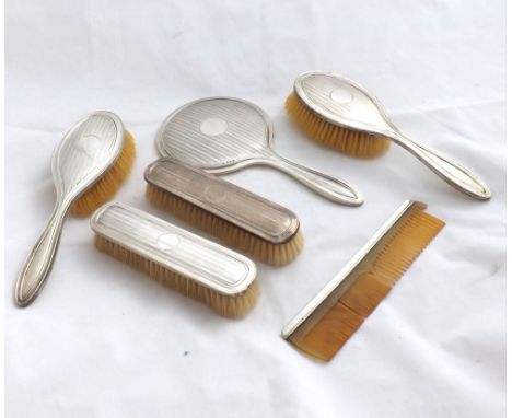 A Composite Six Piece Dressing Table Set comprising: Hand Mirror, four Brushes and Silver-backed Comb, all pieces with engine