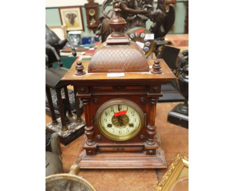 Junghard eight day mantel clock, the oak case surmounted by three finials, circular brass and enamel dial in the ornate carve
