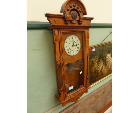 Small oak ornate carved cased striking wall clock with rectangular glazed panel to front and circular enamel dial inset roman