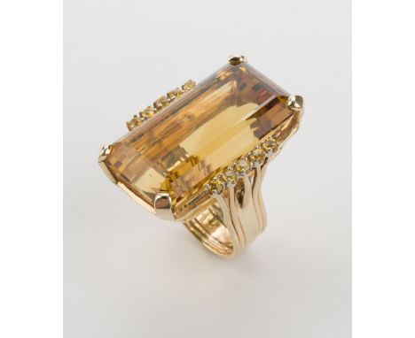 DESCRIPTION: 14k ring set with rectangular step cut citrine, approximately 67 carats by formula. Set to sides with ten .08 ca