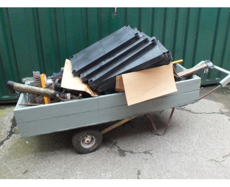 A handmade pull along garden trolley and contents including plastic shelving, garden tools etc