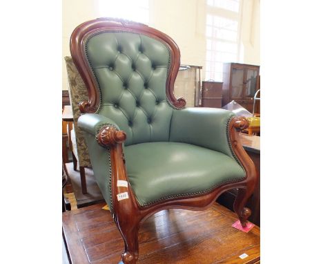 A mahogany framed button back armchair with green leather upholstery
