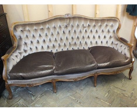 A reproduction curved back, button back saloon suite in brown velvet style upholstery consisting of a settee and two armchair