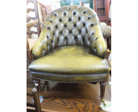 A spoon armchair with green leather studded button back upholstery