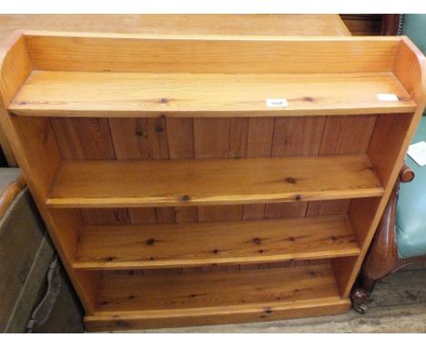 A pine four shelf floor standing bookcase and a satinwood chest of two short and two long drawers