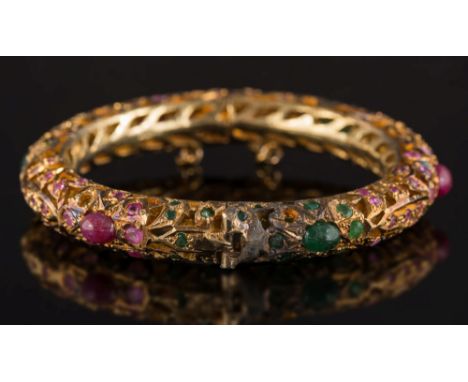 An Indian style emerald and ruby mounted bangle: with cabochon and circular-cut emeralds and rubies, approximately 45gms gros