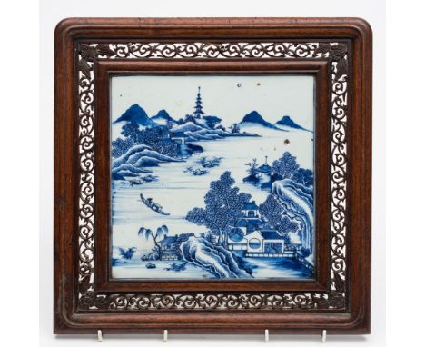 A Chinese blue and white porcelain and hardwood table screen: the square porcelain panel painted with an extensive lake lands