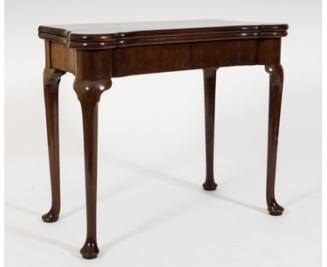 A George II mahogany concertina action card table:, of shaped outline, the hinged top with projecting rounded corners, enclos