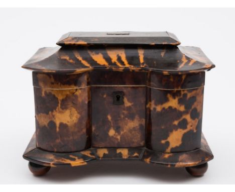 A 19th century tortoiseshell tea caddy: of serpentine outline, with shallow domed hinged lid, enclosing two lidded foil lined