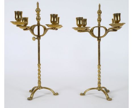 A matched pair of 19th century brass four-branch candelabra: with plain urn-shaped nozzles with circular sconces on a crucifo