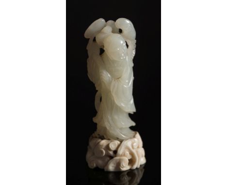 A Chinese carved  jade carving of a man holding lingzhi sprays: with smiling expression and wearing elaborate robes, the ston