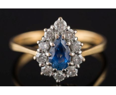 An 18ct gold, sapphire and diamond pear shaped cluster ring: the pear shaped sapphire within a surround of circular, brillian