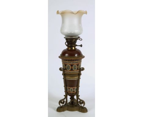 A Mettlach pottery and brass mounted oil lamp: of ovoid tapering form, decorated with oval floral medallions, enclosed in a b