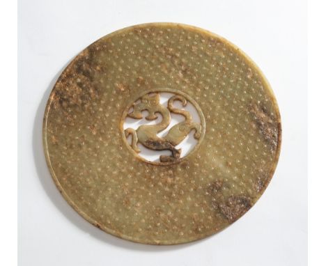 A large Chinese carved archaistic jade disc, Bi: in Han Dynasty style, the centre carved and reticulated with a sinuous drago