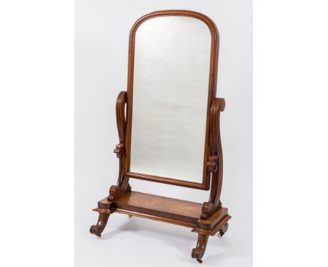 A Victorian mahogany swing frame cheval mirror:, the plate with an arched moulded surround, having moulded scroll uprights ca