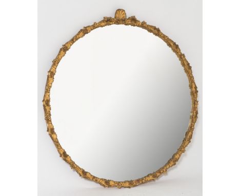 A gilt gesso framed circular mirror:, the plate within a surround decorated with flowerheadas, rocaille, scrollwork and surmo