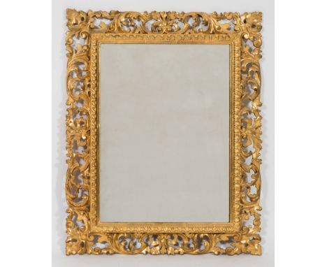 A carved giltwood Florentine frame rectangular mirror:, the plate within a moulded fluted slip and pierced acanthus decorated
