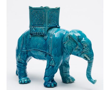A majolica planter in the form of an elephant: modelled standing with curled trunk and supporting a blanket and howdah on it'