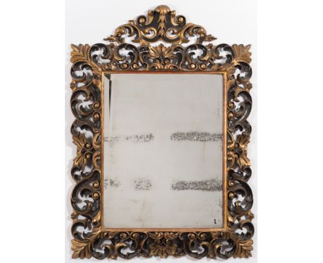 A late 19th century carved giltwood and ebonised Florentine frame wall mirror:, the rectangular plate within a pierced acanth