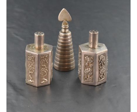 A near pair of Chinese silver coloured white metal pepperettes, having cylindrical pierced pull-off covers over the hexagonal