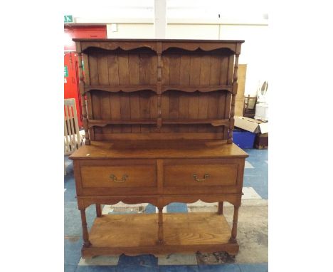 A Small Oak Dresser The Base with Two Drawers and Pot Shelf, Raised Two Tier Plate Rack with Turned Supports.