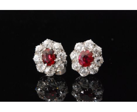 A pair of mid 20th Century 18ct white gold ruby and diamond cluster stud earrings, central oval ruby within a eight stone old