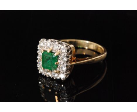 A mid 20th Century 18ct emerald and diamond cluster ring, central square cut emerald within twelve stone brilliant cut diamon