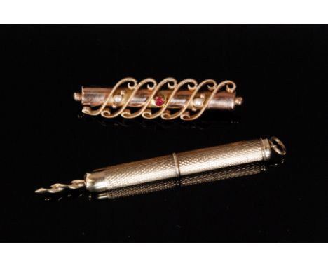 A 9ct hallmarked retractable cigar piercer with engine turned decoration, together with an earlier 9ct stone set bar brooch. 