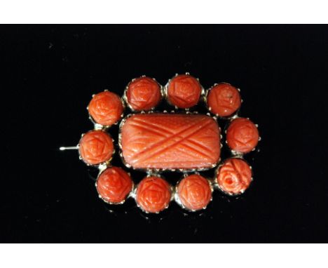 A Georgian rectangular coral mourning brooch, central coral panel with hair panel to reverse within ten coral flower head bor