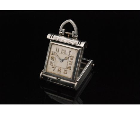 An Art Deco silver and black enamelled folding travel clock designed as a miniature handbag with engine turned and linear dec