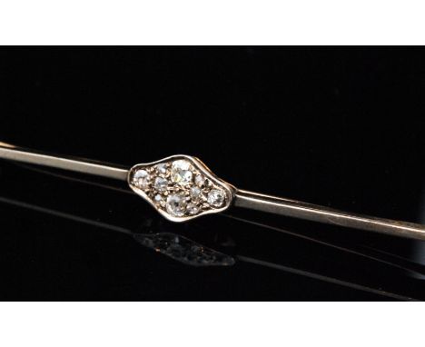 An early 20th Century 15ct bar brooch with ten pave set old cut stones to a cushioned oval central panel, length 7.5cm. 