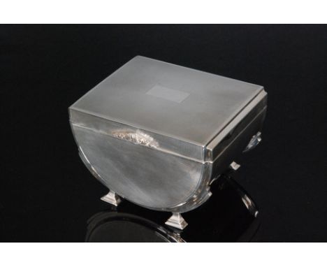 An Art Deco hallmarked silver cigarette box of half barrel form with engine turned decoration, hinged lid and foliate cast th