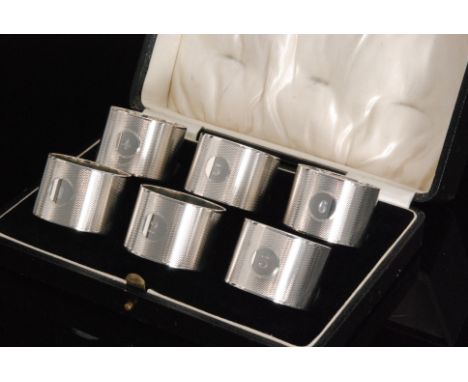A cased set of six napkin rings, each with engine turned decoration and numbered 1 through to 6, Birmingham 1932, Adie Brothe