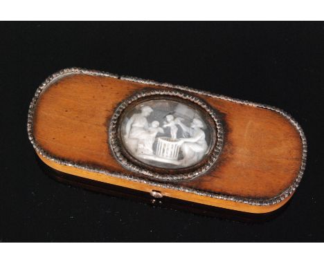 An 18th Century oval boxwood patch box with central oval panel detailed with classical figures and a cherub within cut steel 