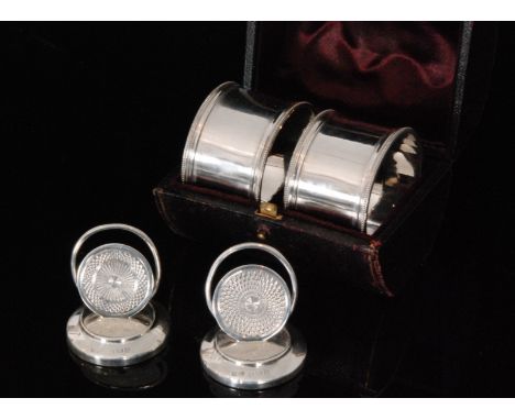 A cased set of two Victorian hallmarked silver napkin rings, each of plain circular form with beeded rim, Edinburgh MacKay Cu