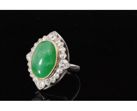 An 18ct white gold jade and diamond cluster ring, central oval collar set jade within  a twenty stone old cut diamond surroun