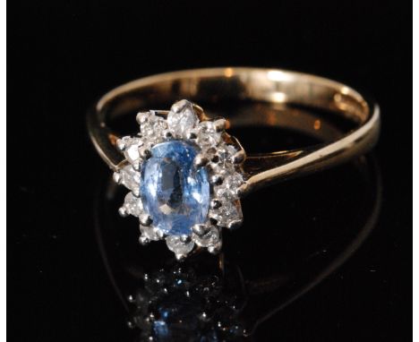 A 9ct hallmarked blue topaz and diamond cluster ring, central oval topaz within twelve stone diamond surround, all stones cla