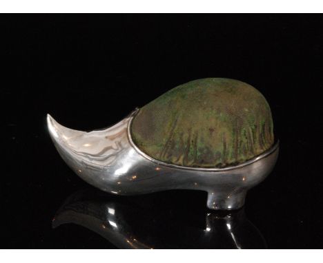 An Edwardian hallmarked silver pin cushion of plain from modelled as a lady's shoe with up turned toe, length 10cm, Birmingha