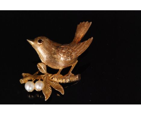 A mid 20th Century 9ct hallmarked brooch modelled as a robin perched on a branch, with ruby set eye, the branch highlighted b
