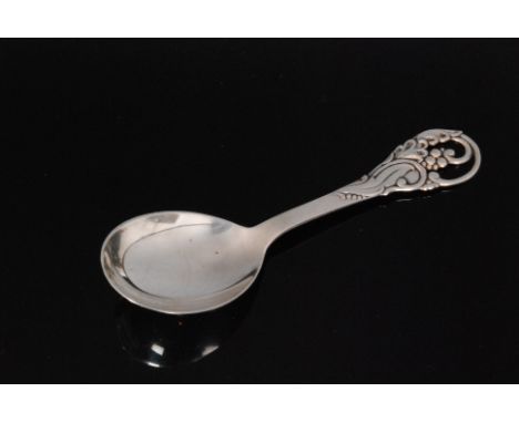 A Danish sterling silver caddy spoon the plain bowl extending to foliate terminal with sinuous scrolling leaf and berry decor