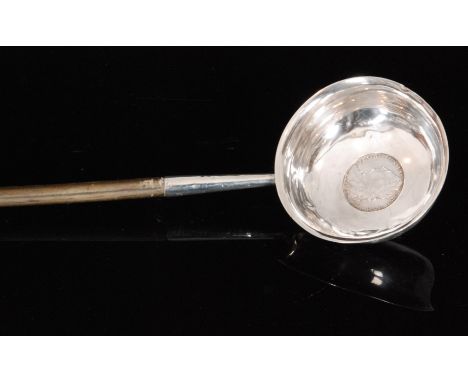 A Georgian silver toddy ladle, circular bowl with inset shilling dated 1745 all below twisted whale bone handle, length 42cm.