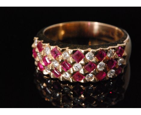 A 14ct ruby and diamond ring comprising three rows of alternating horizontally set brilliant and square cut stones to plain t