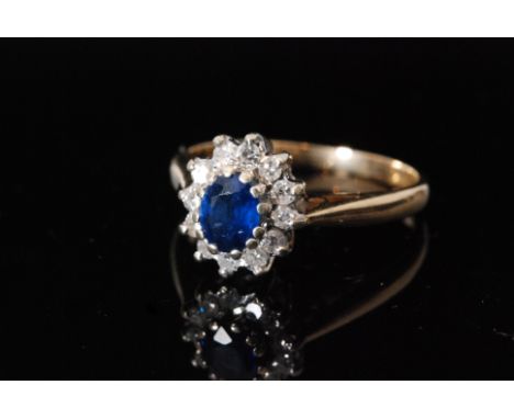 A 9ct hallmarked sapphire and diamond cluster ring, central oval sapphire within twelve stone brilliant cut diamond surround,