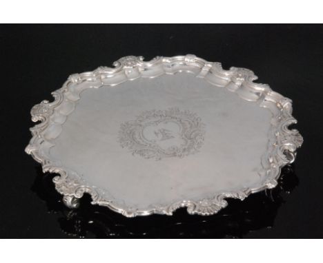 A George II hallmarked silver circular salver with central engraved crest of a sea eagle within foliate surround all within l